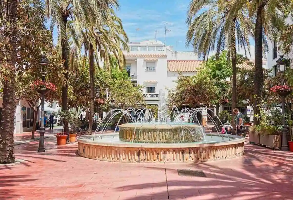 Split view of Estepona old town flower-lined street and Marbella Puerto Banus marina at night, Costa del Sol Spain