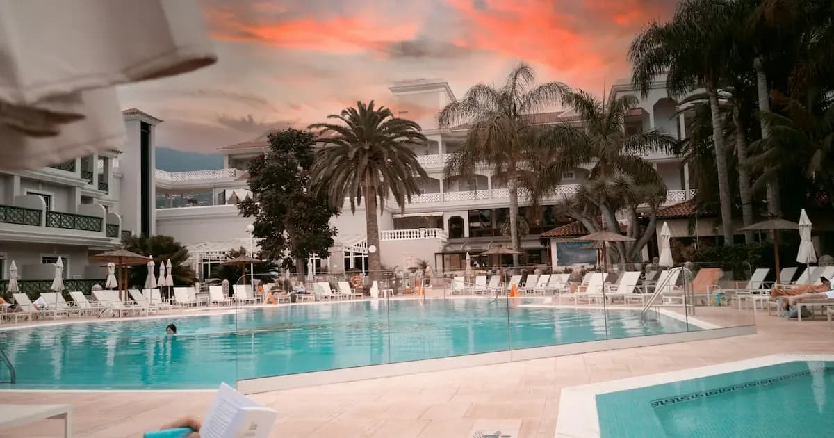 family-friendly hotel pool in Spain with palm trees at sunset