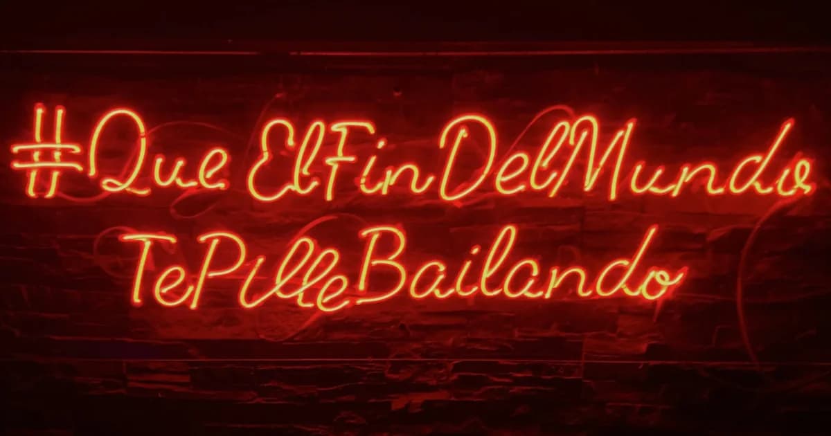 Malaga nightlife neon sign: #QueElFinDelMundoTePilleBailando (May the end of the world find you dancing)