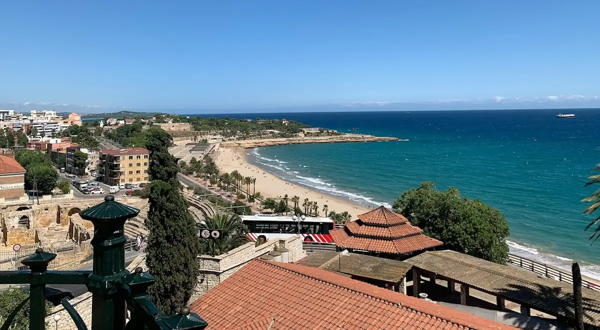 Sea view hotel in Spain overlooking sandy beach, turquoise Mediterranean waters and coastal city skyline.