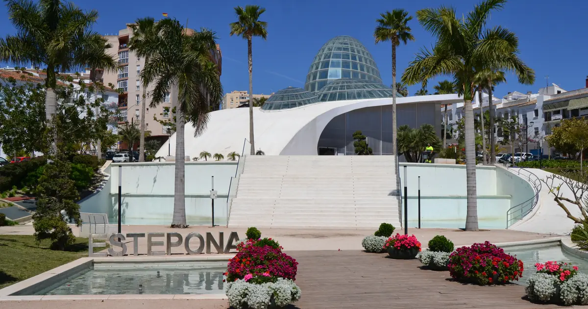 Estepona Orchidarium glass dome and white modern building with palm trees and flowers in front, in Estepona Spain