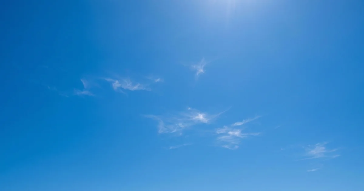Malaga weather in August with intense blue sky and minimal small white clouds, typical hot clear summer conditions on Costa del Sol