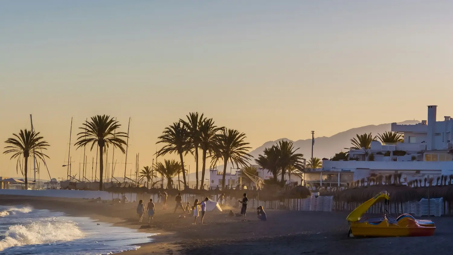 Clear turquoise water at a Blue Flag beach in Marbella with golden sand and La Concha mountain in the background