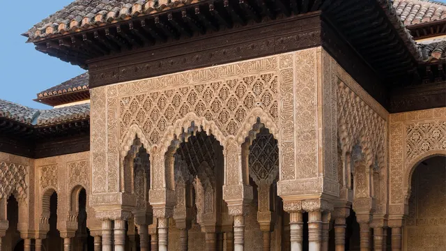 Ornate Nasrid stucco archways in the Alhambra's Court of the Lions in Granada