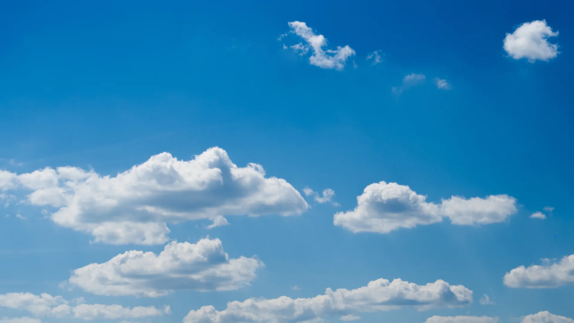 Bright blue sky in benalmadena spain with scattered white clouds.