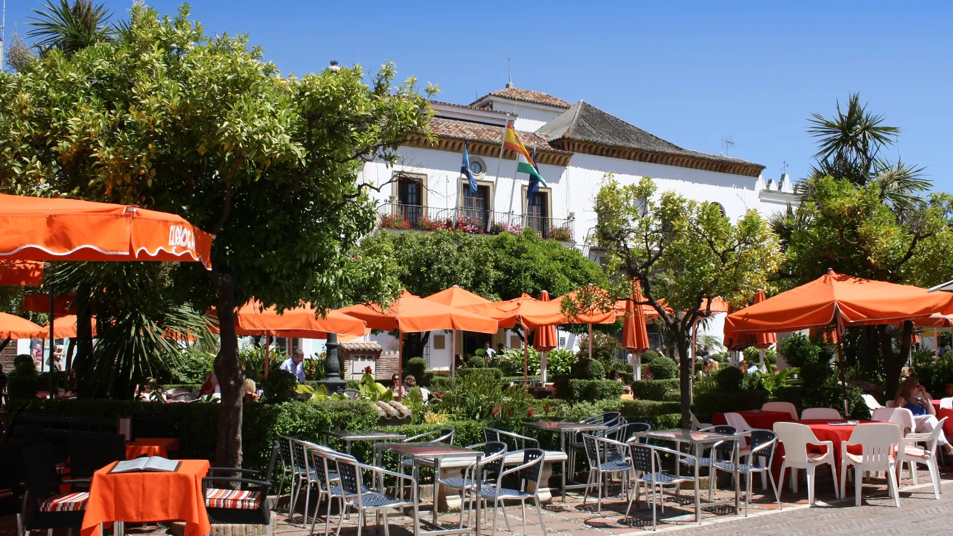 Café terraces with orange parasols on Plaza de los Naranjos in Marbella's old town