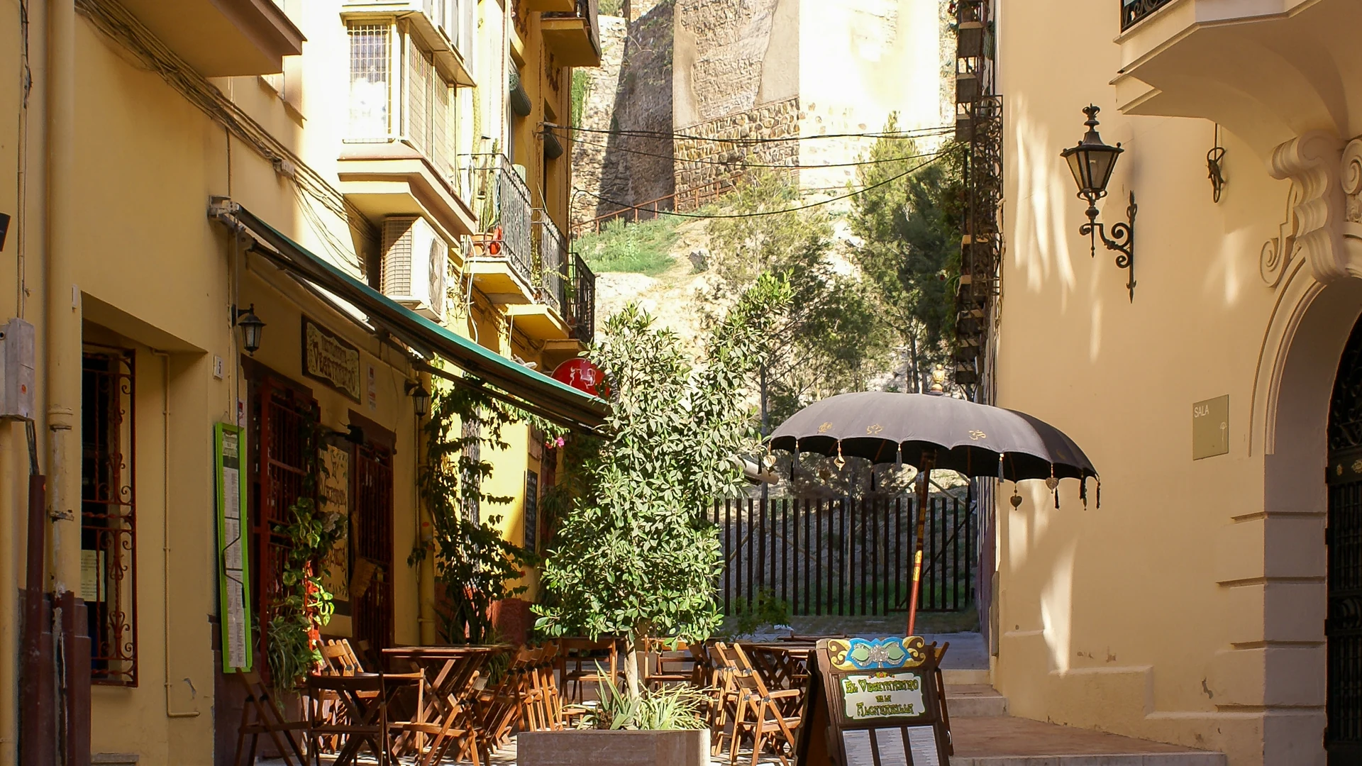 A narrow street in Malaga's historic centre lined with townhouses