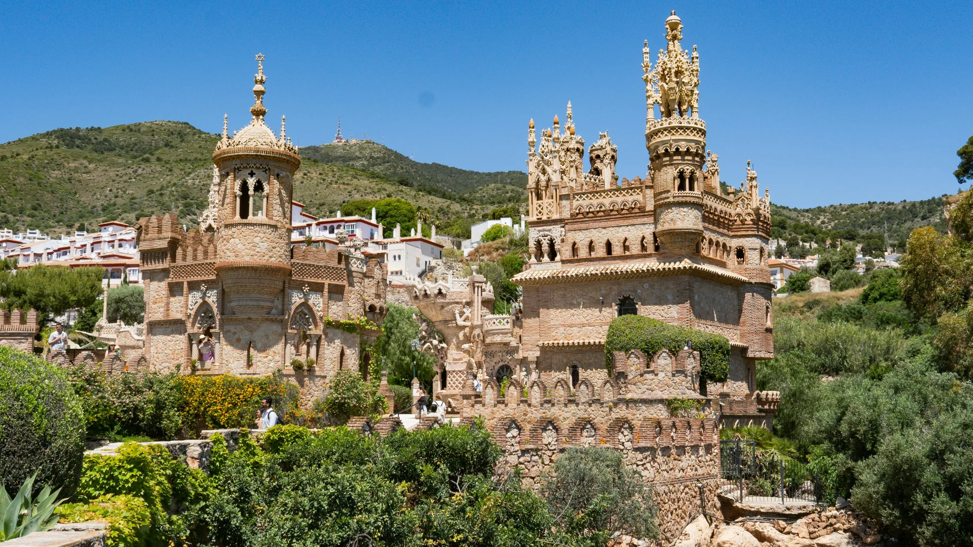 Colomares Castle in Benalmádena, Spain – mosaic-covered towers and arches of the monument to Christopher Columbus against a blue sky.