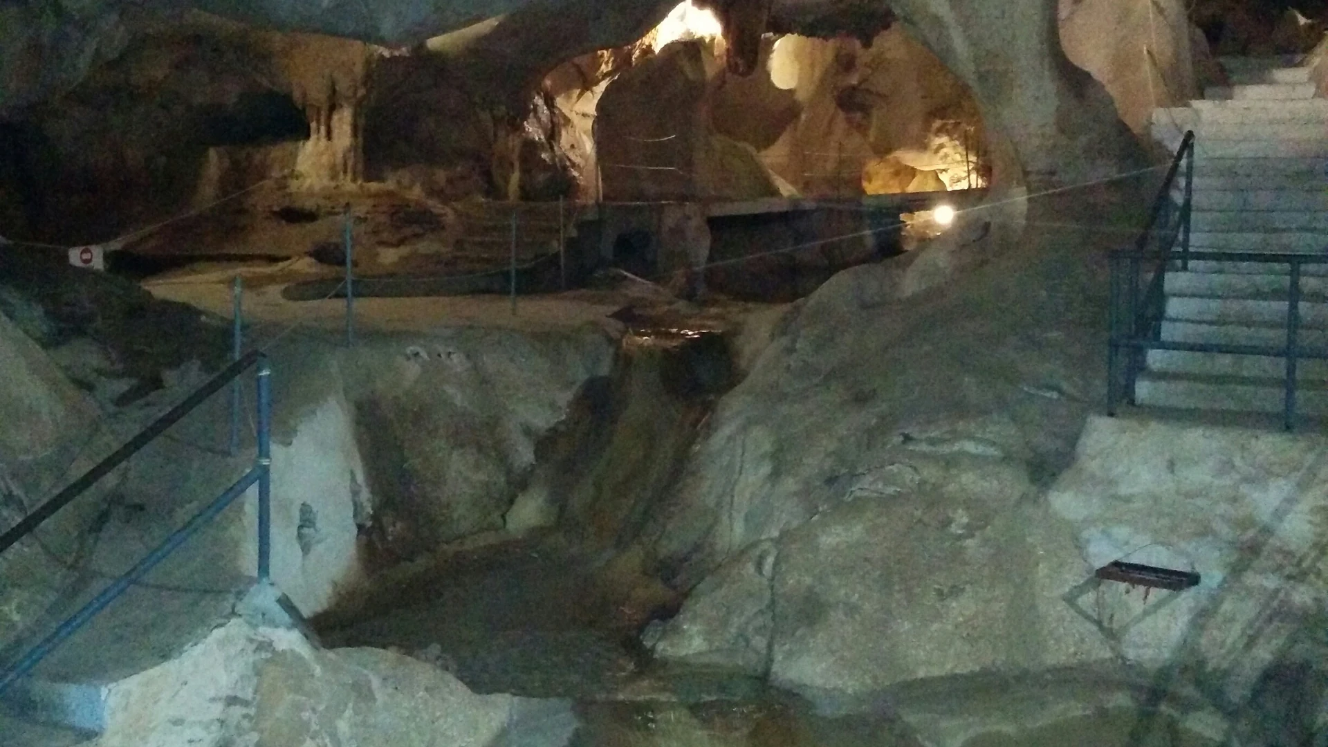 The chamber of lakes inside Cueva del Tesoro, with cave walls reflected in the still underground water