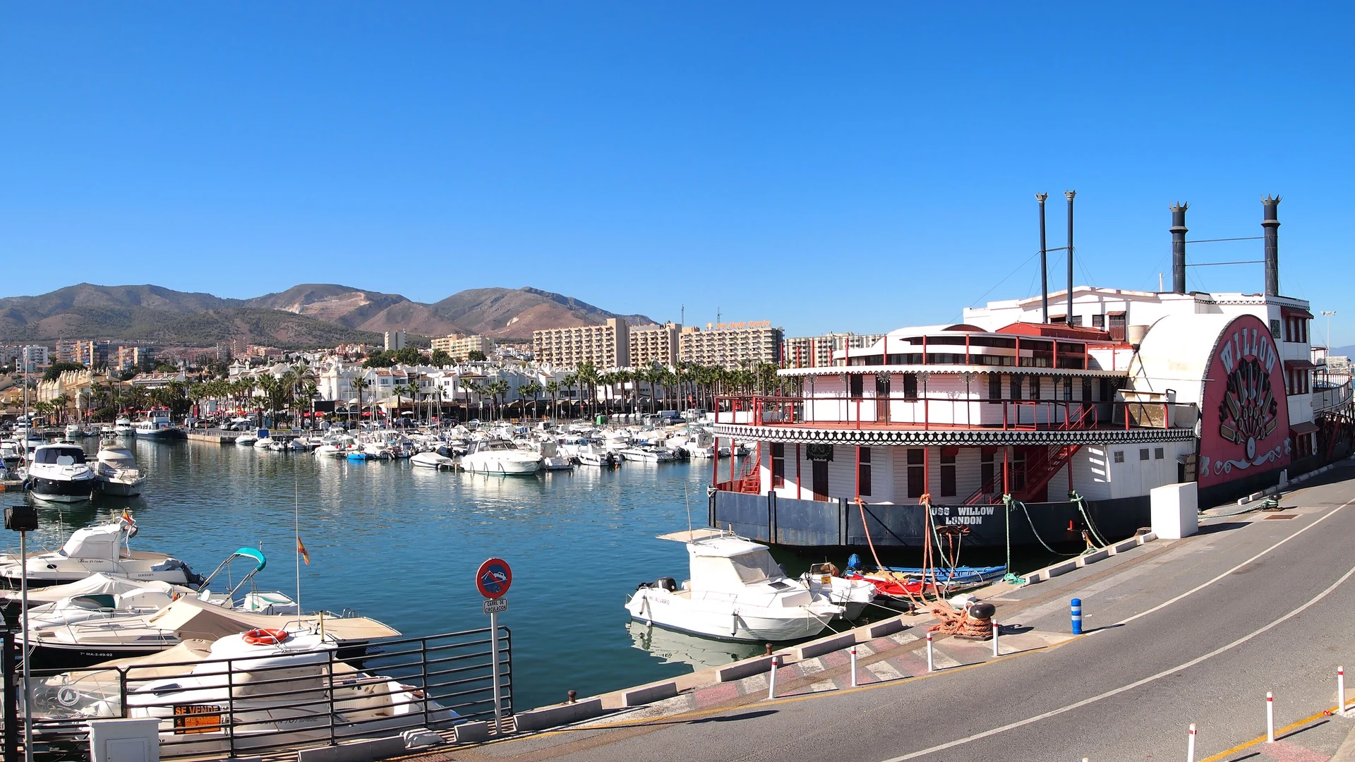 Puerto Marina in Benalmádena, with boats moored in the harbour and the Sierra de Mijas mountains behind the town