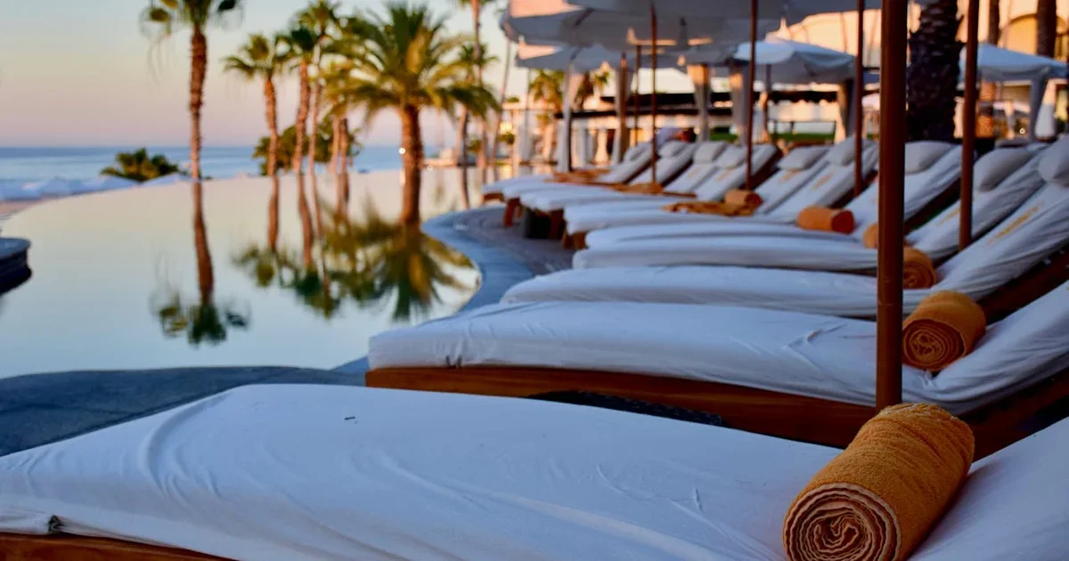 Sun loungers and parasols on a beach club terrace in Estepona with calm blue Mediterranean sea and clear sky