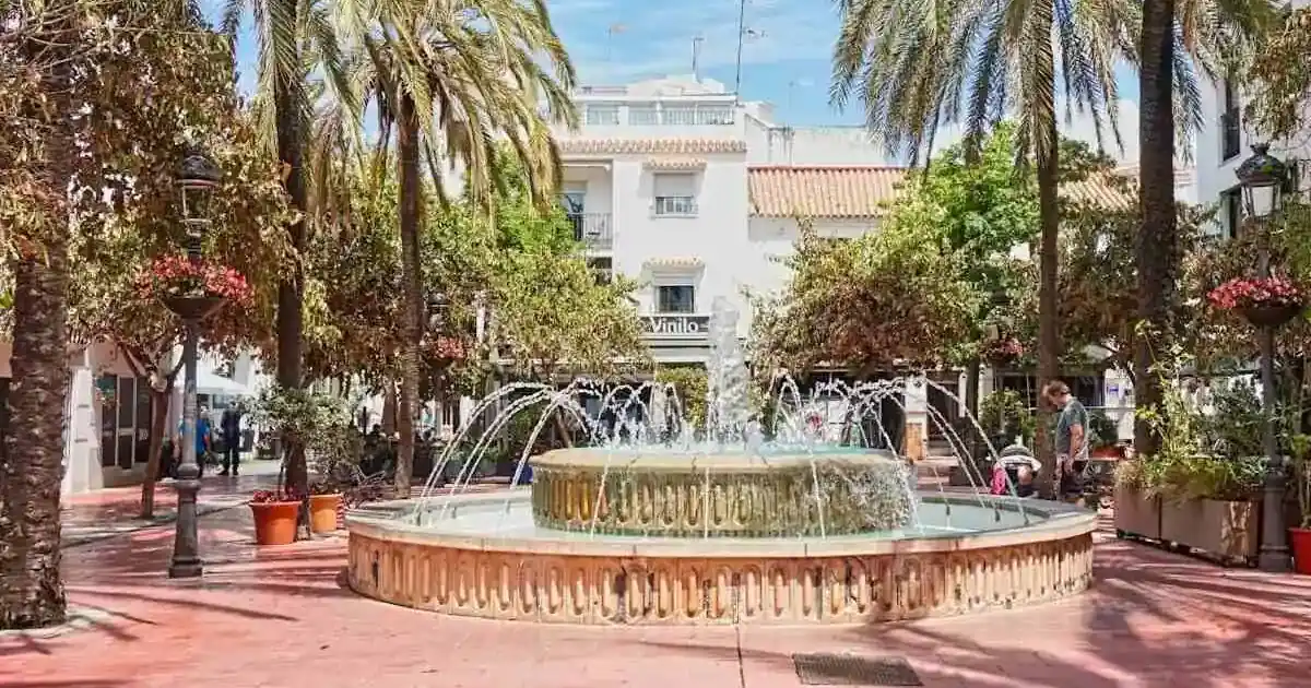 A small park with a fountain in the middle in Estepona