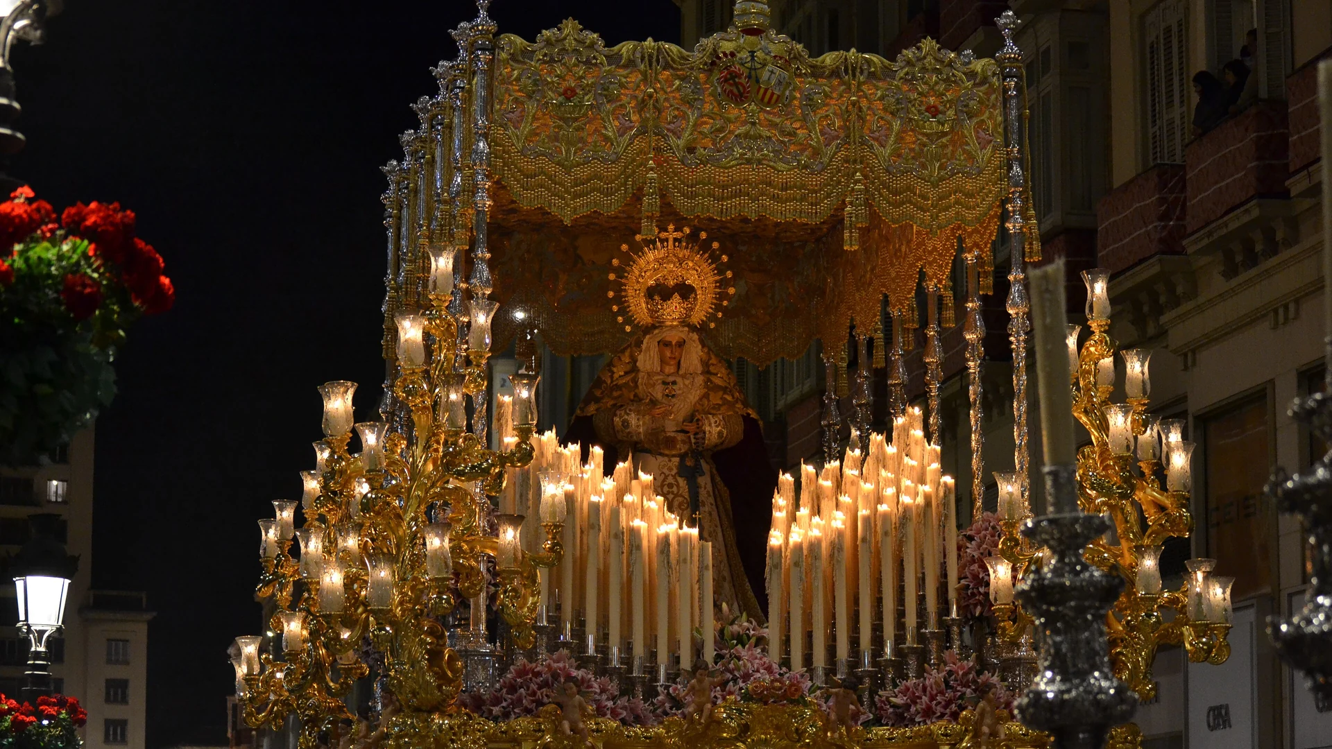 A candlelit Semana Santa trono carried through Malaga at night
