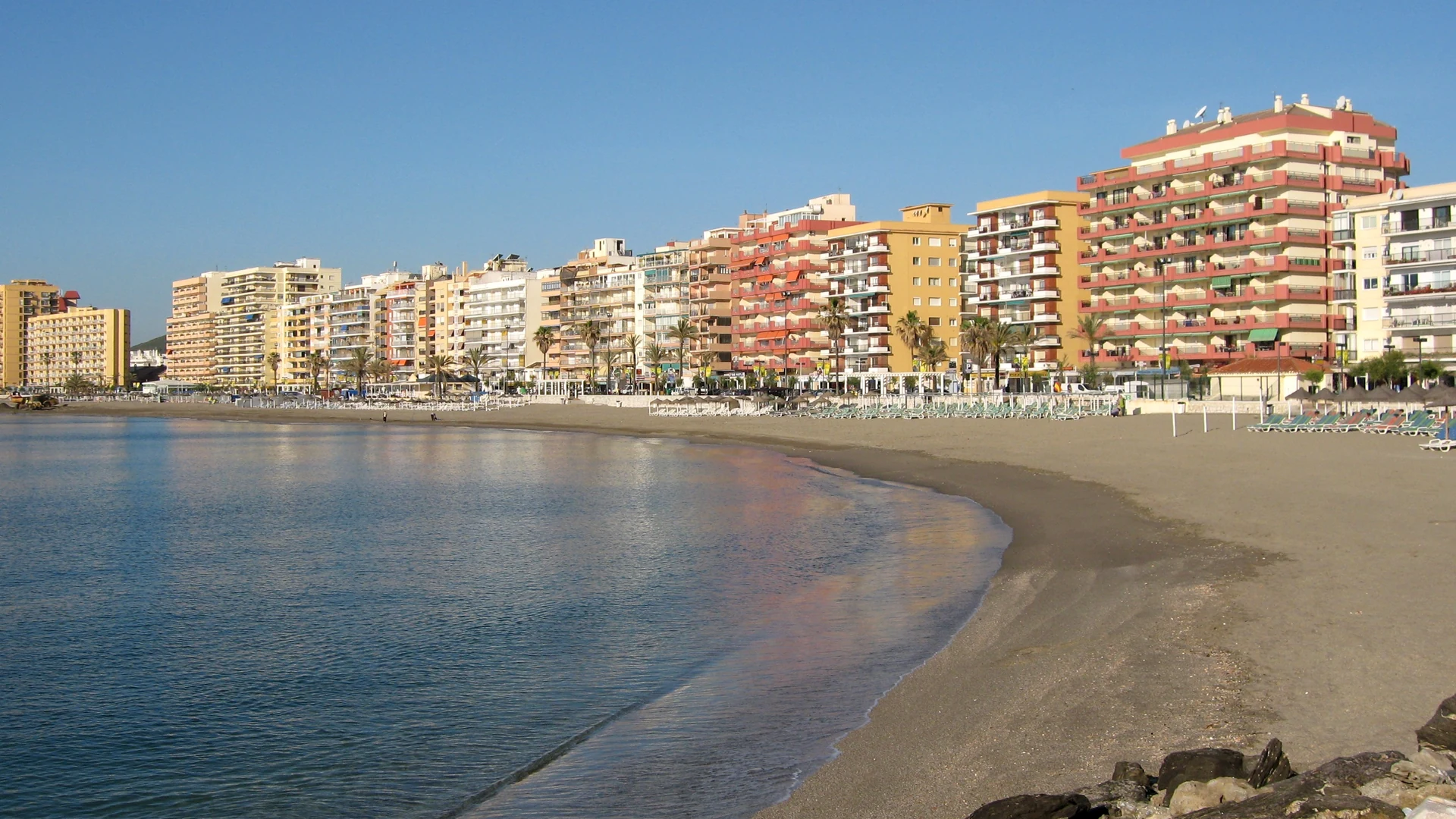 Fuengirola beach and seafront apartment blocks under a clear winter sky