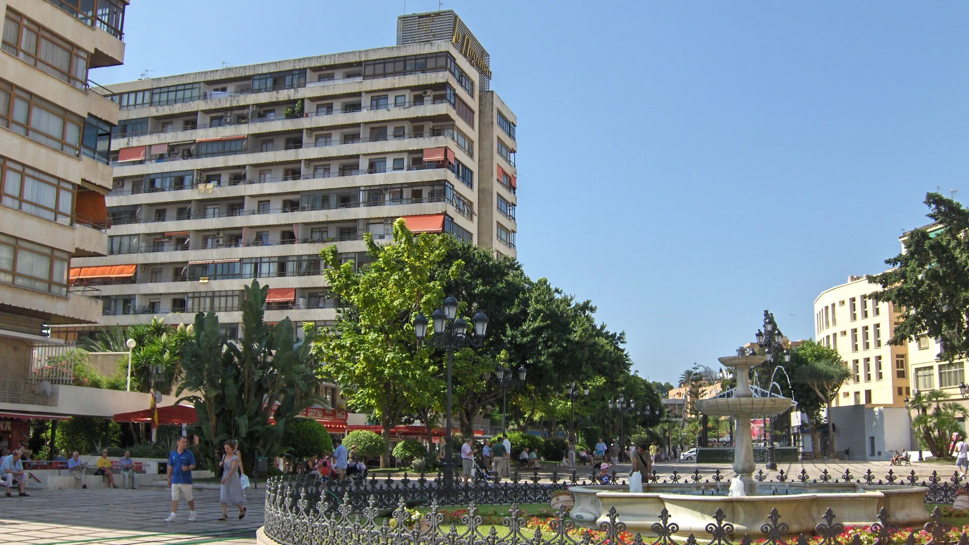The pedestrian square at La Nogalera in Torremolinos, with a fountain, trees and the tower block that carries the La Nogalera name