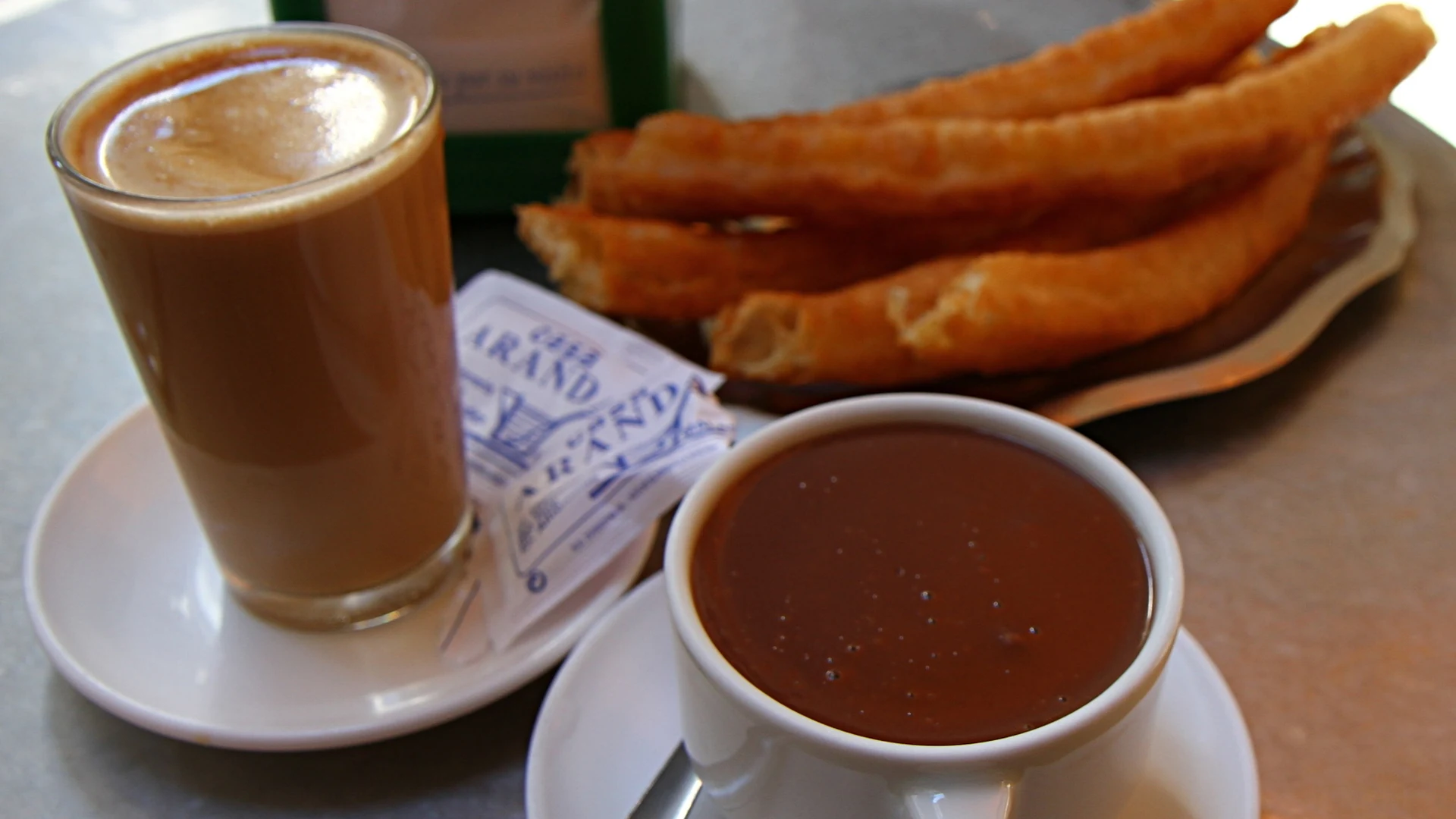 Churros z gorącą czekoladą i café con leche w Casa Aranda w Maladze.