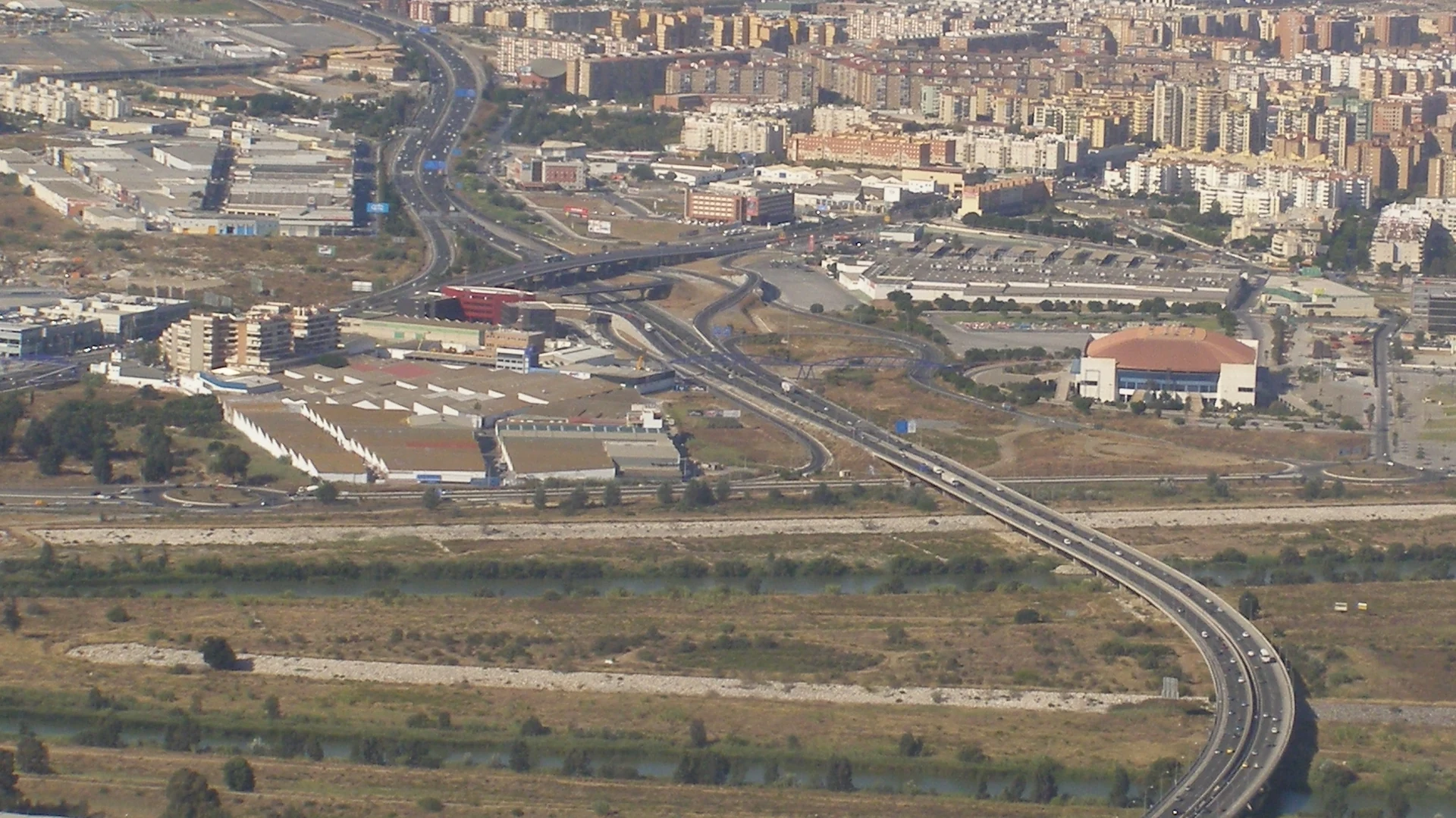 Malaga z lotu ptaka: miasto, obwodnica i zabudowa nad Morzem Śródziemnym.