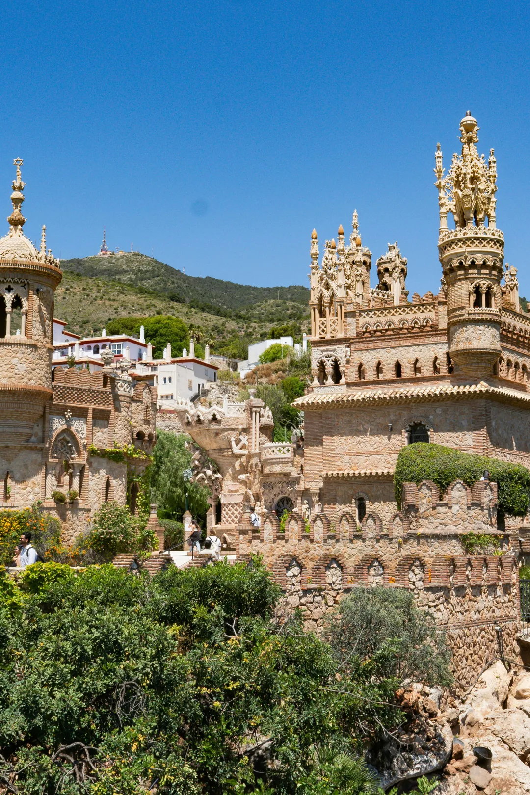 Colomares Castle in Benalmádena, Spain – mosaic-covered towers and arches of the monument to Christopher Columbus against a blue sky.