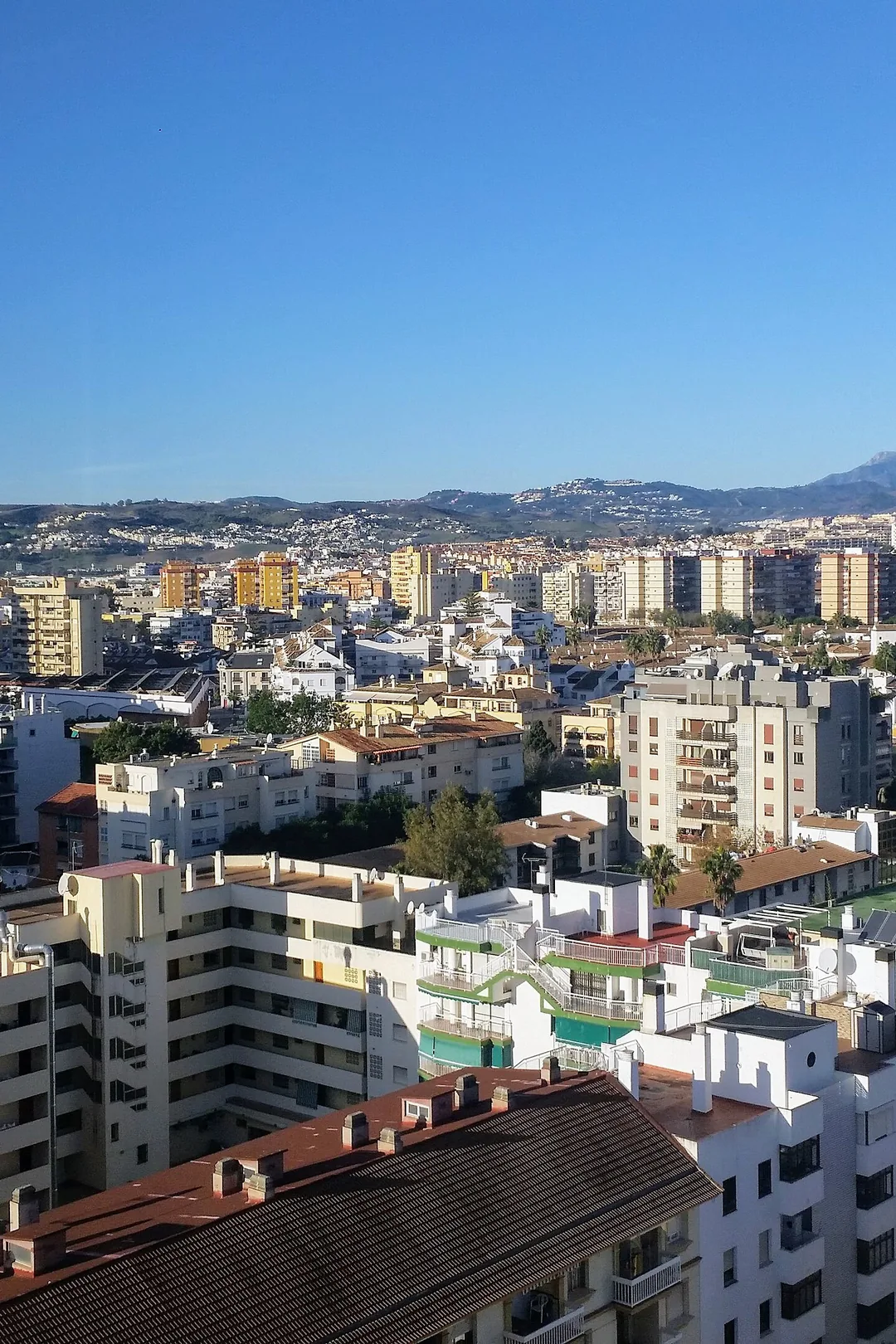 High-rise hotels and apartment blocks across Fuengirola with the mountains behind