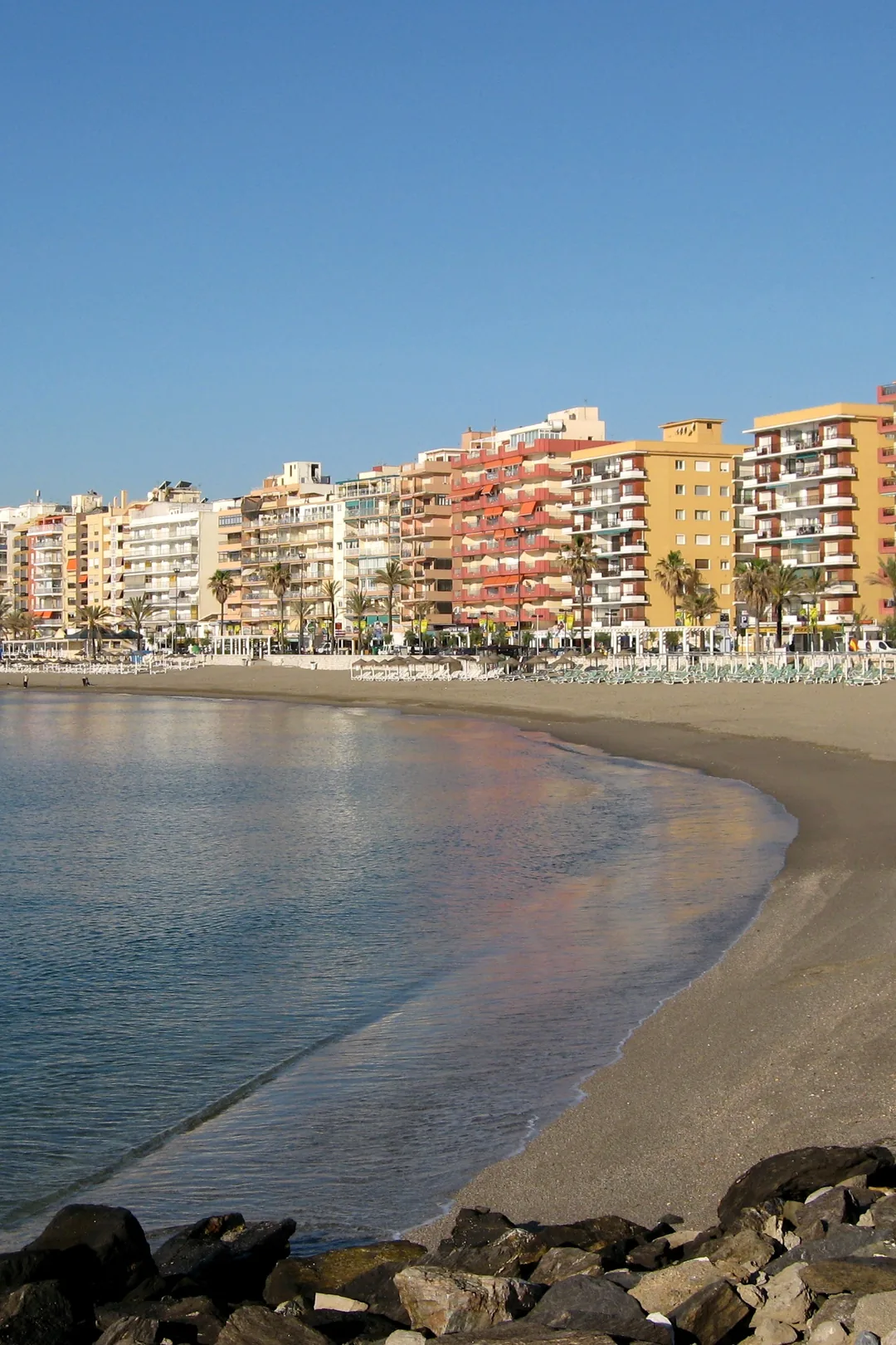 Fuengirola beach and seafront apartment blocks under a clear winter sky