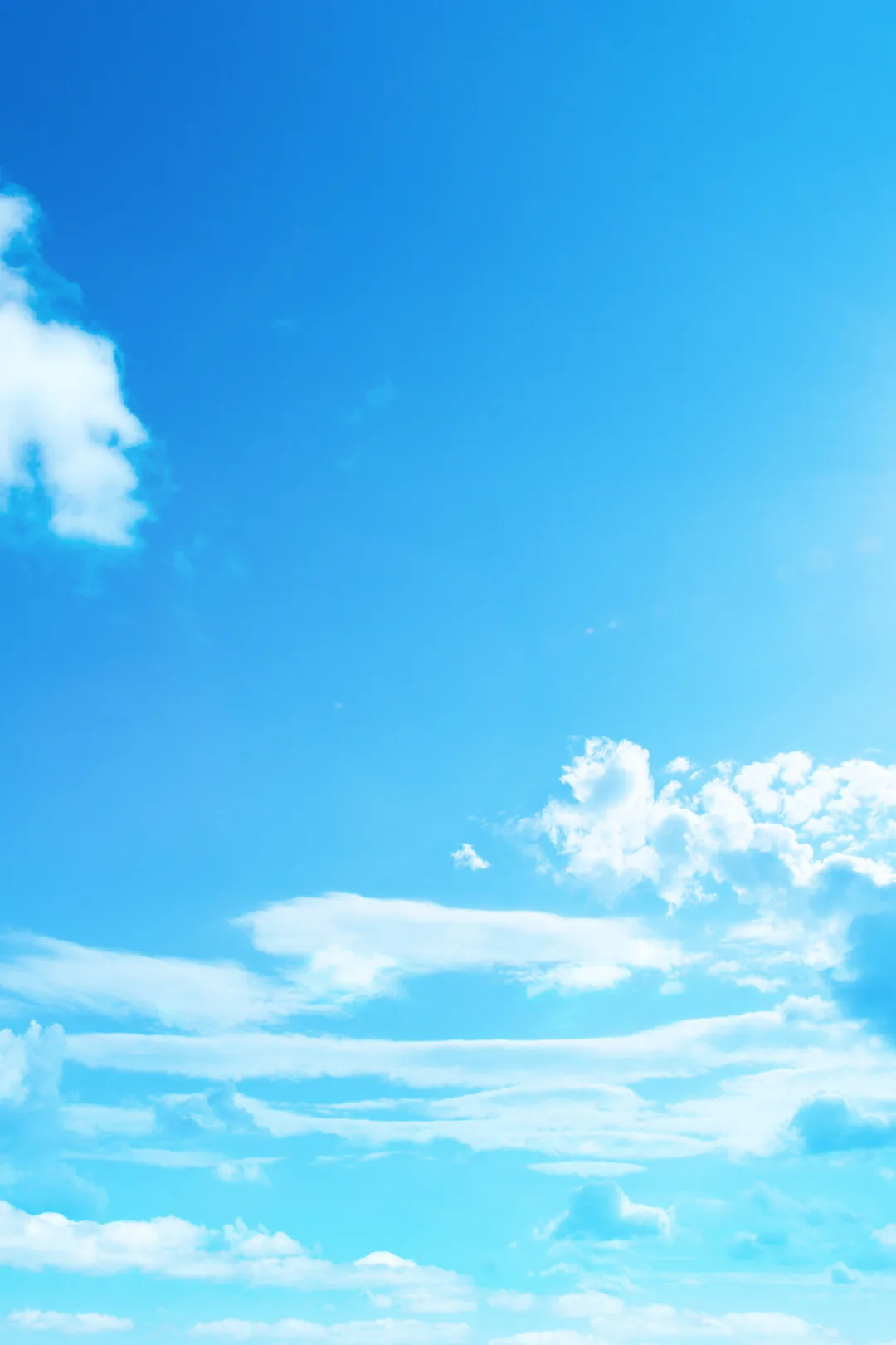 Bright blue sunny sky with scattered white clouds representing the warm and sunny weather in Fuengirola, Spain.