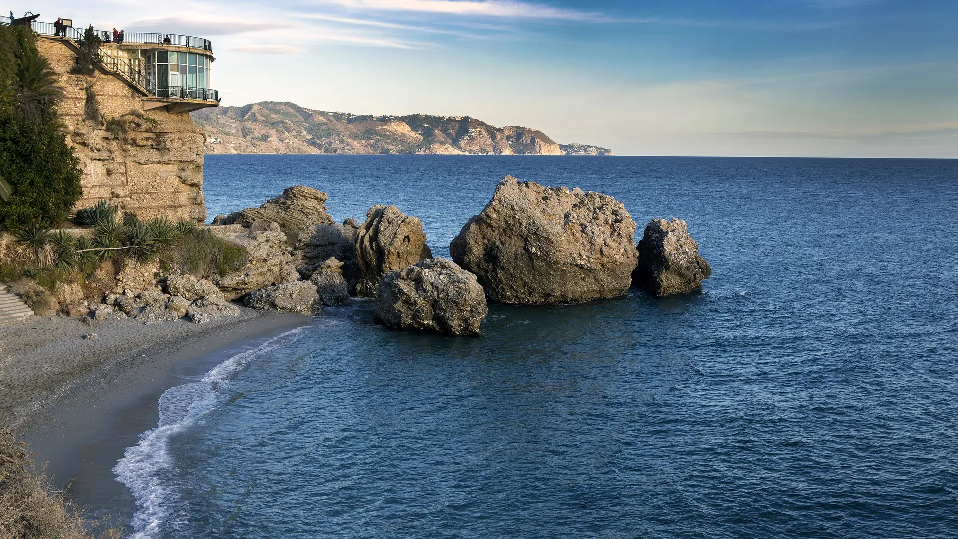 Nerja's whitewashed town and coastline under clear blue summer skies on the Costa del Sol