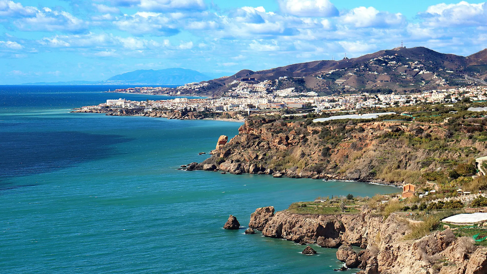 The Costa del Sol coastline near Nerja seen from the sea, with cliffs dropping to the Mediterranean