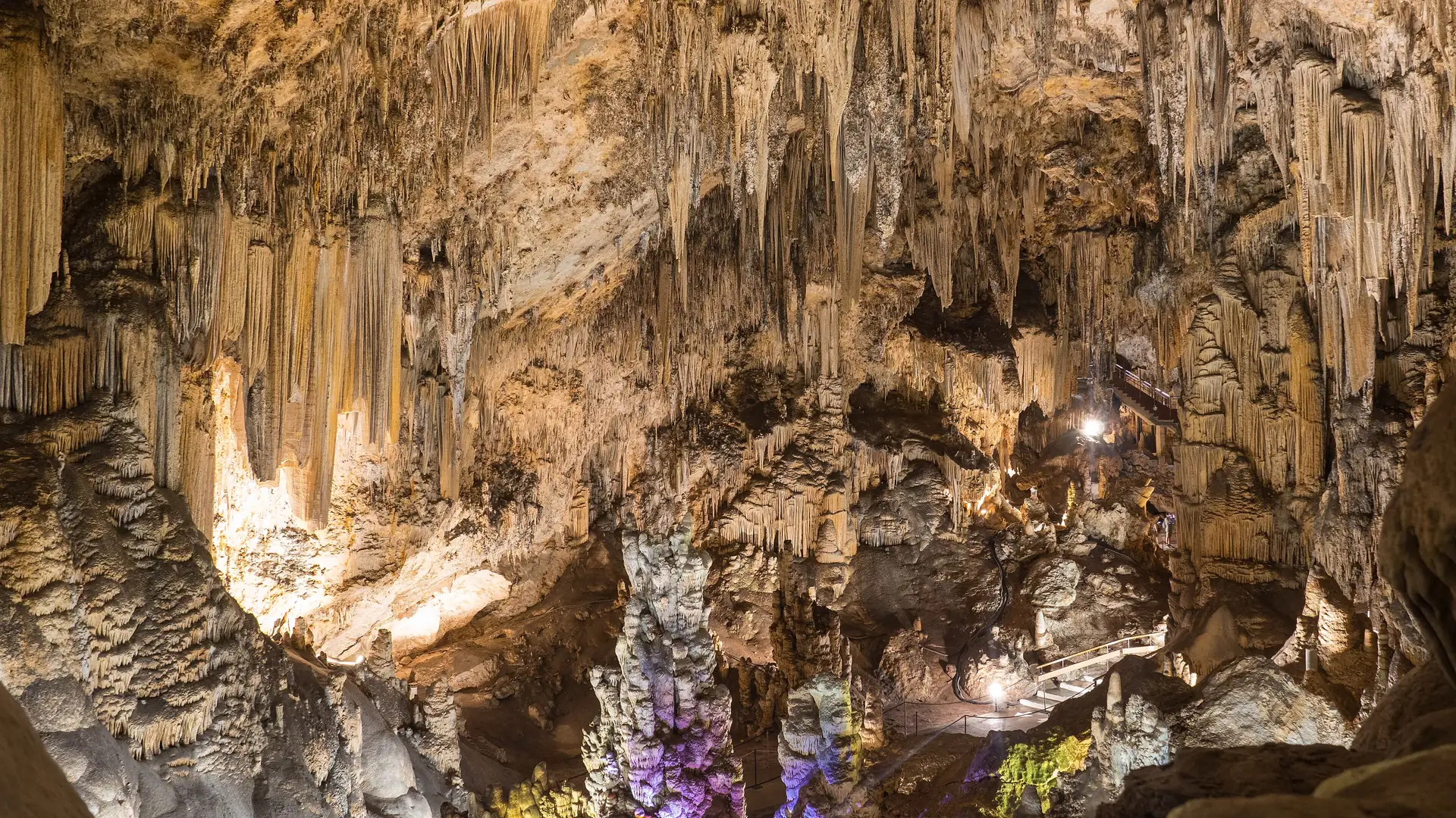 Vast illuminated chamber inside the Cuevas de Nerja with towering stalactite and stalagmite formations