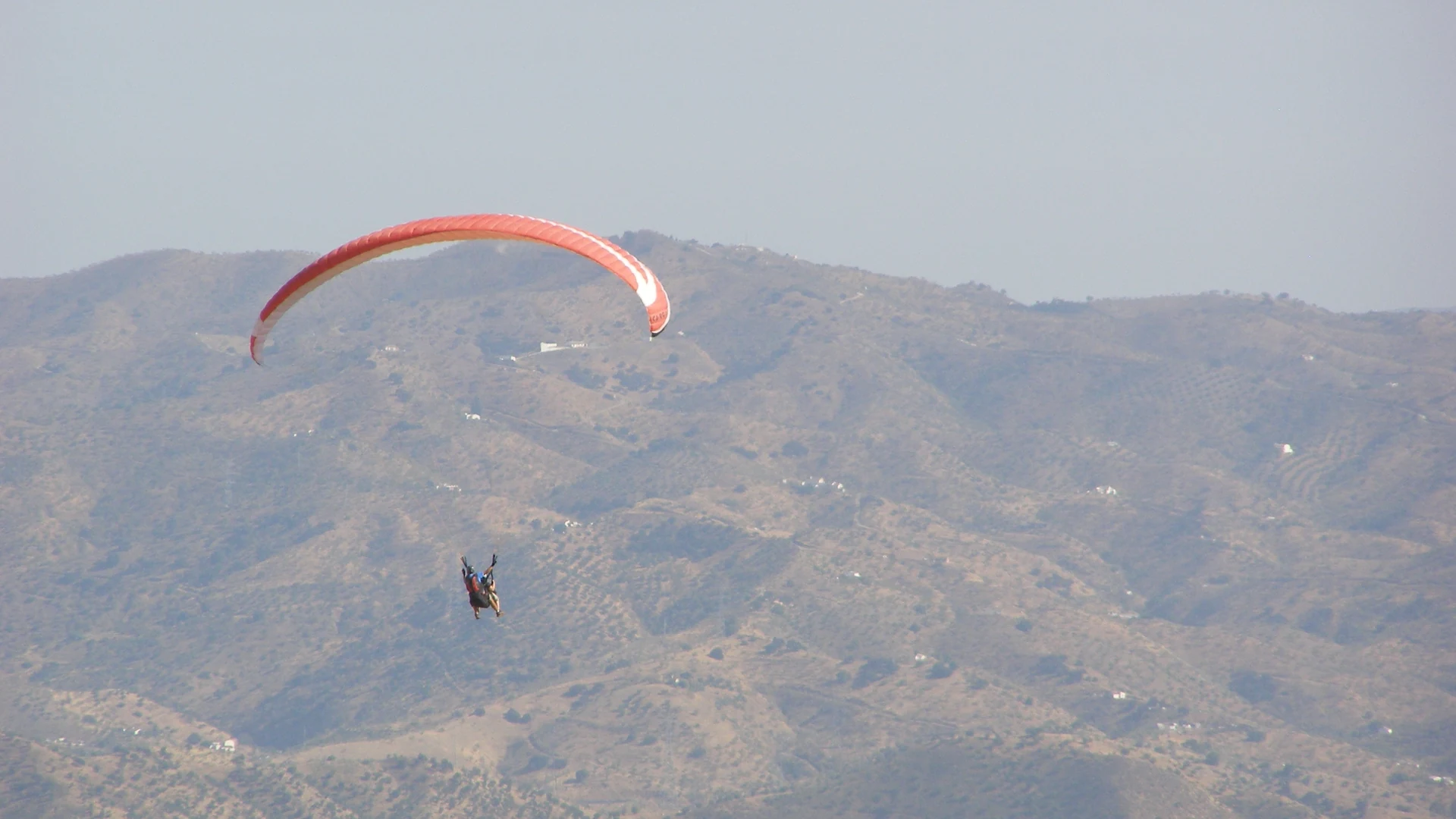 Paraglider soaring above the Valle de Abdalajís in the mountains of Málaga province with valley views below