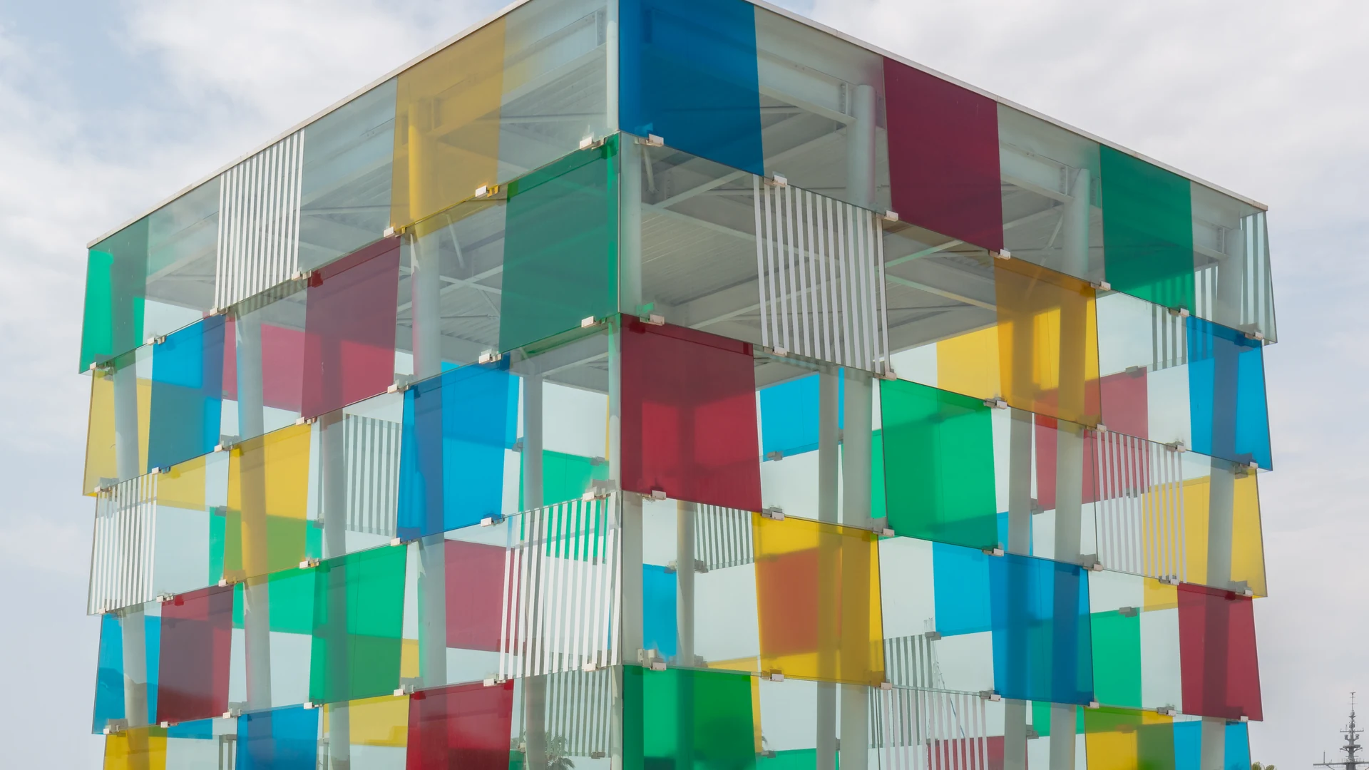 The colourful glass Cube of Centre Pompidou Málaga at Muelle Uno, with multicoloured panels in the sun