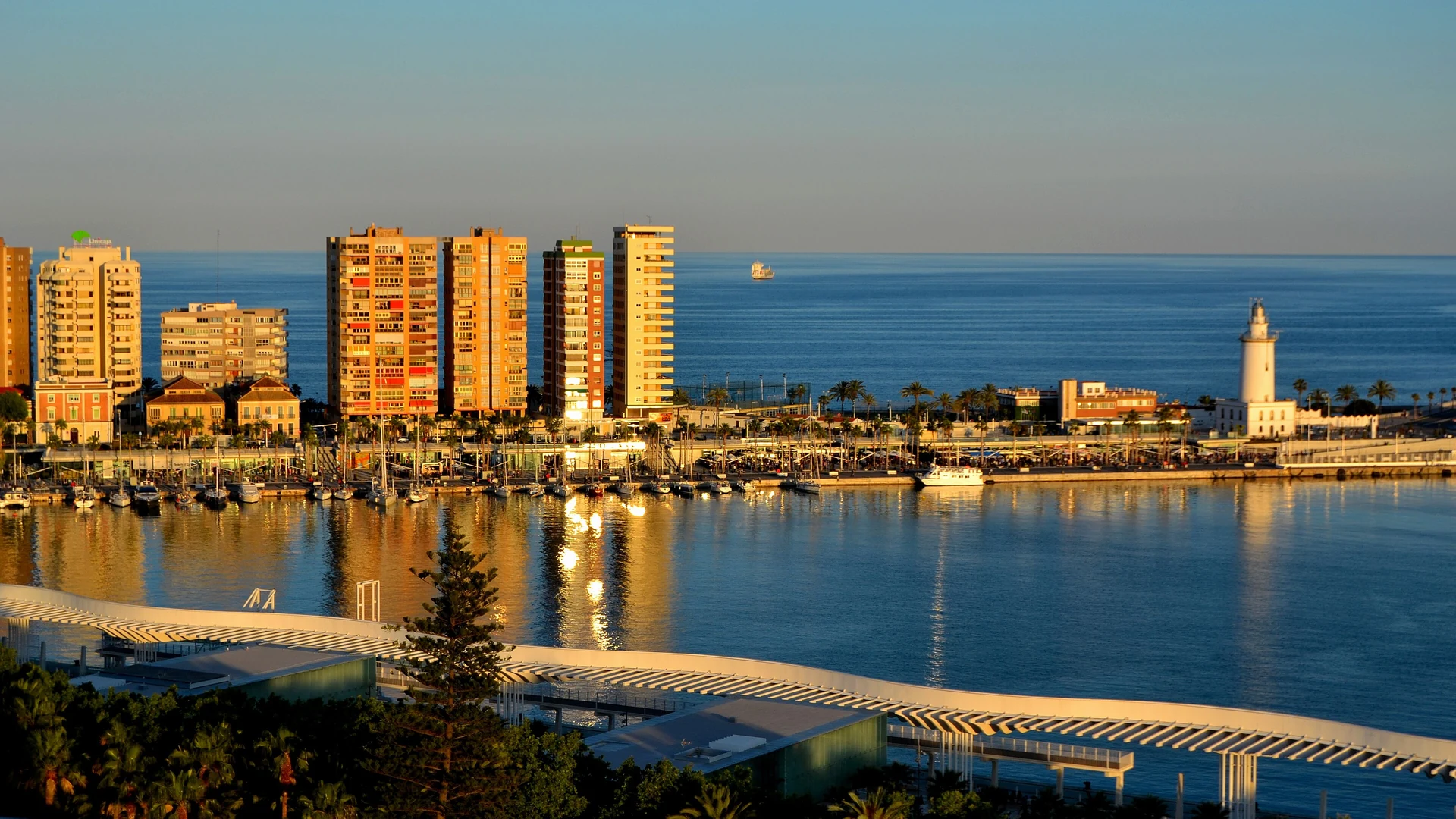 The Muelle Uno waterfront promenade at Malaga port with moored yachts and the city behind