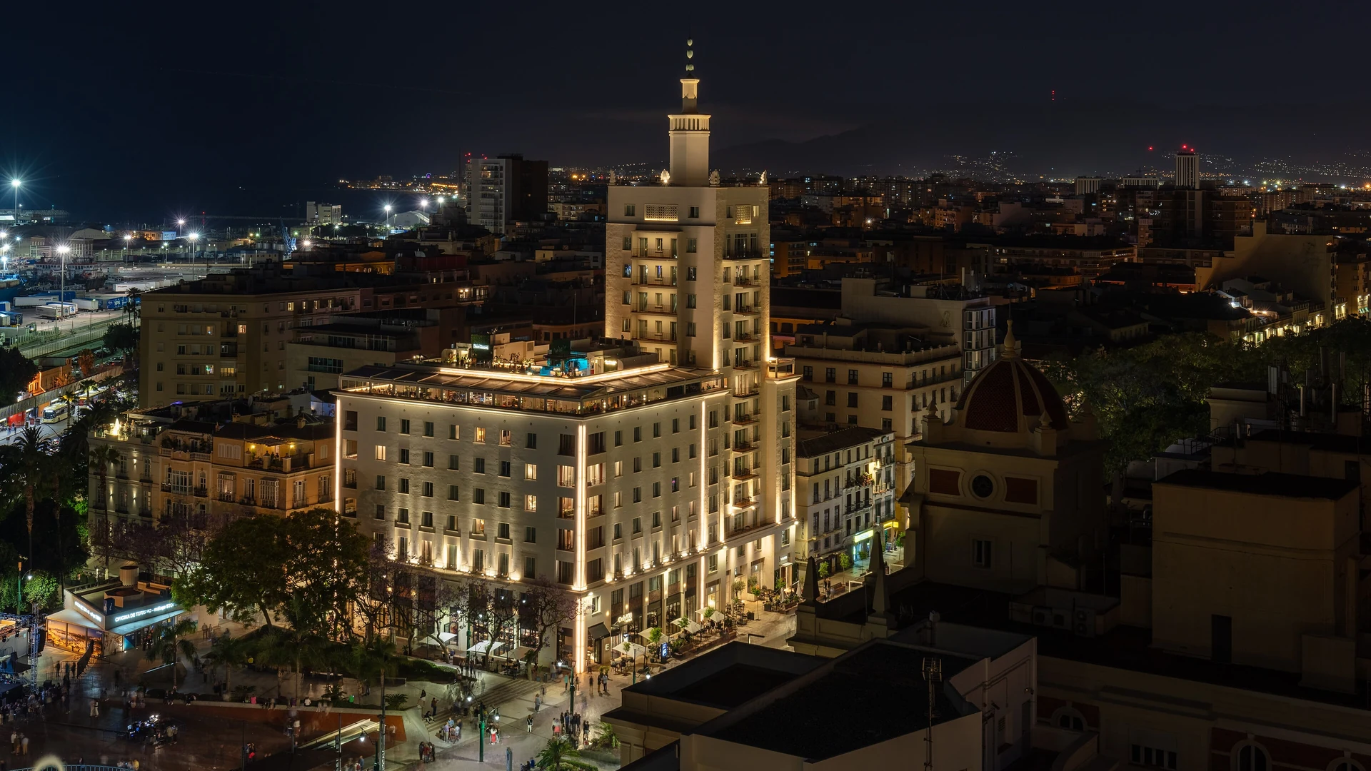 The Only YOU Hotel Malaga lit up at night, with its rooftop terrace above the city