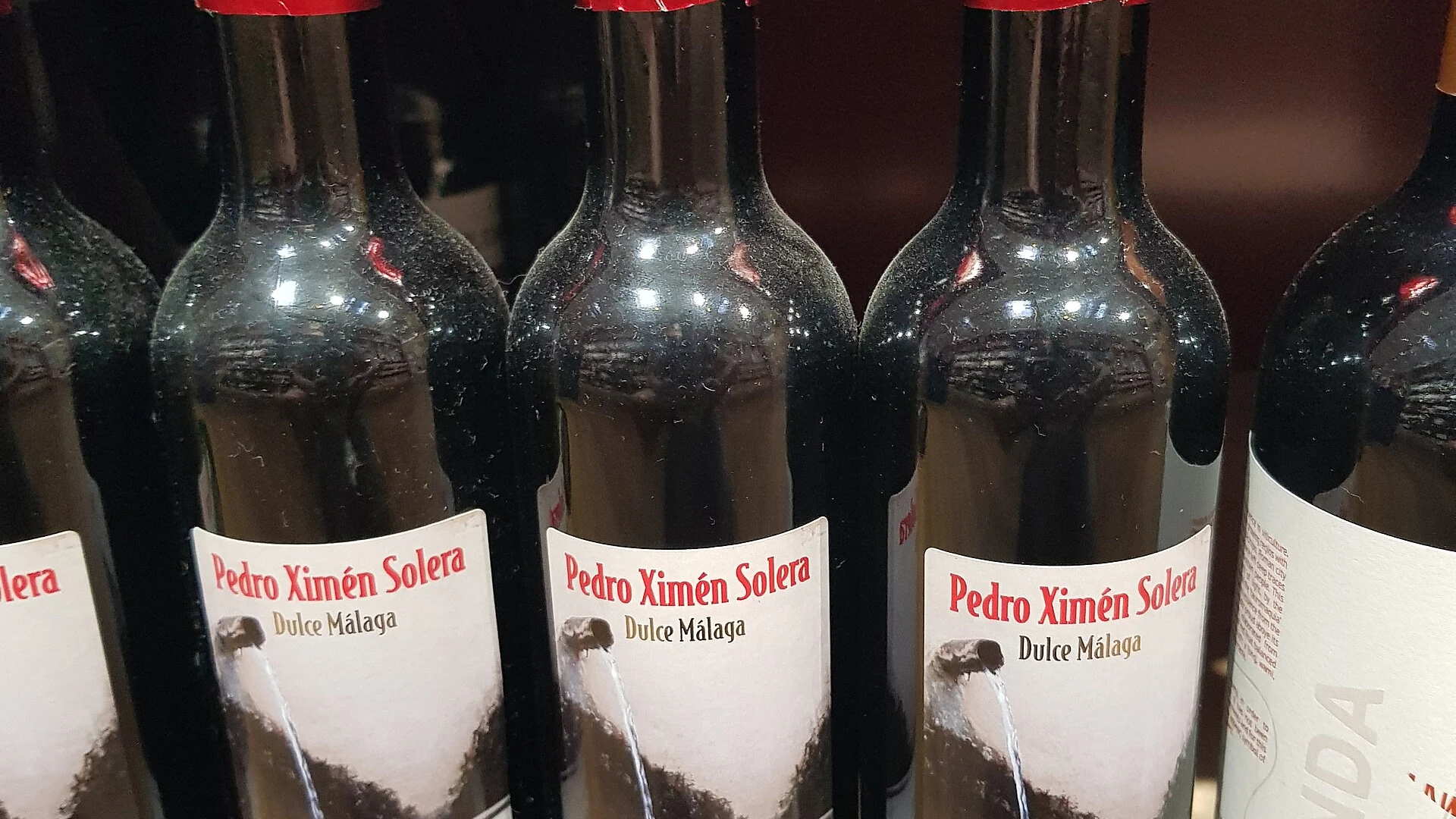A glass of dark amber Malaga sweet wine, made from Pedro Ximénez grapes