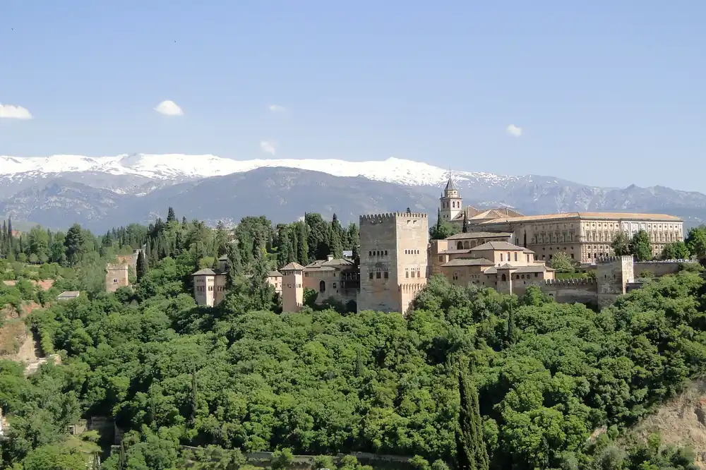 The Alhambra palace complex above Granada with the snow-capped Sierra Nevada behind